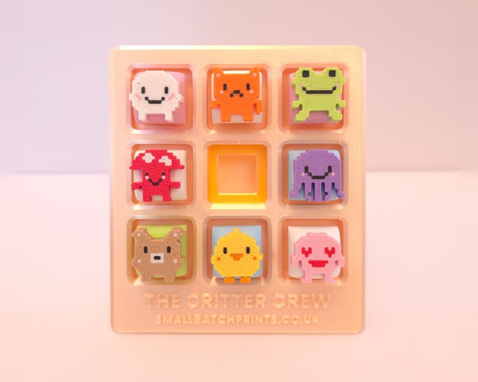 The Critter Crew display board with all eight pixel critter keycaps in their spots and the gold middle spot waiting for the King